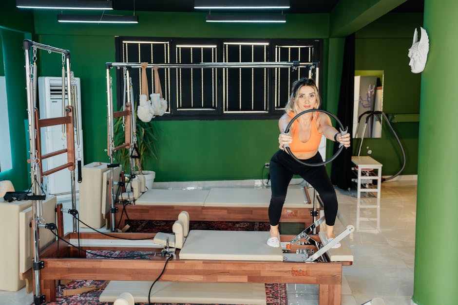 Fitness enthusiast practicing Pilates on a reformer machine in a modern, brightly lit studio